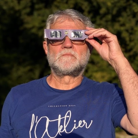 Portrait de Stéphane Canu, en plein air, portant des lunettes d'observation solaire